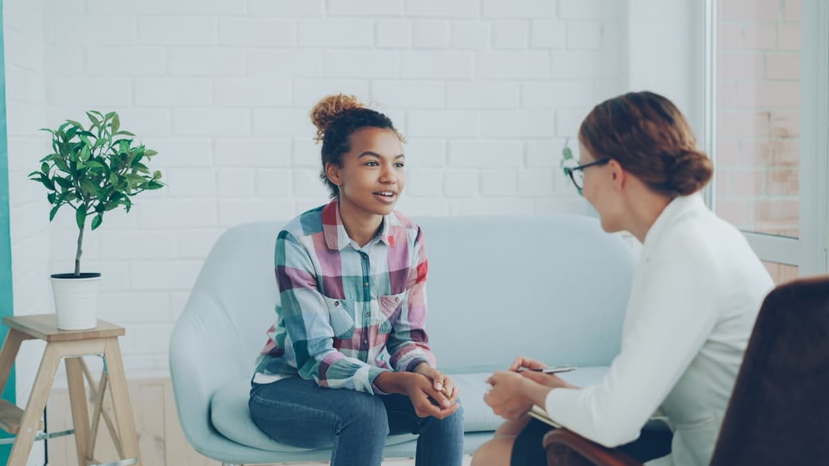 Profesional de la salud en sesión con una paciente en su consulta